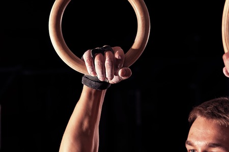 Cropped shot of male athlete doing exercises with gymnastics rings.の写真素材