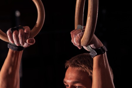Cropped shot of male athlete doing exercises with gymnastics rings.の写真素材