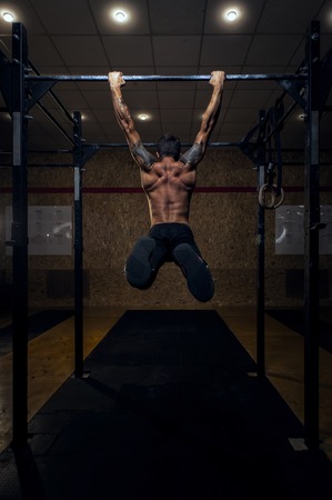 Muscular strong man with on horizontal bar.