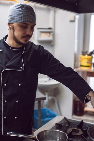 Male cook preparing meal on restaraunt kitchenの写真素材