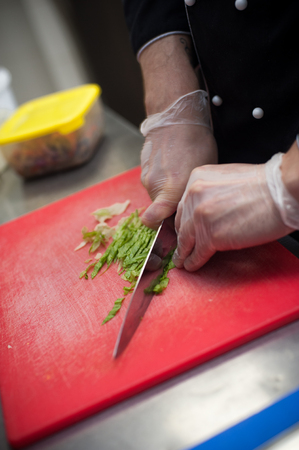 Closeup of male chef hands cutting vegetables