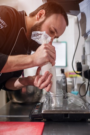 Male bearded chef cooking ice cream in kitchenの写真素材