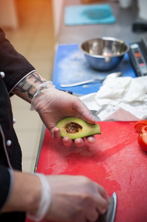Male chef preparing avocado, closeupの写真素材
