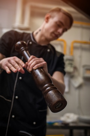 Young caucasian cook in restaraunt kitchen at workの写真素材