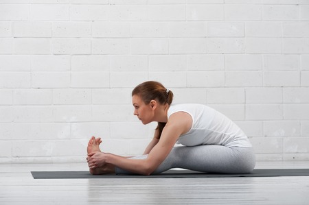 Young attractive woman practicing yoga indoors