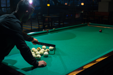 Young caucasian man arranged billiard ballsの写真素材