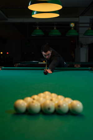 Concentrated man aiming the billiard ballの写真素材