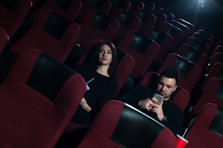 Young caucasian couple sitting in movie theaterの写真素材