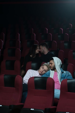 Two romantic couples in movie theaterの写真素材