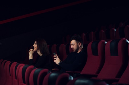 Young caucasian couple sitting in empty theaterの写真素材