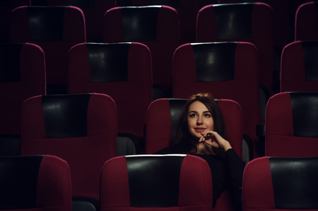 Young attractive brunette woman watching movieの写真素材
