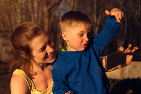 Mother and son making selfie at sunset perkの写真素材