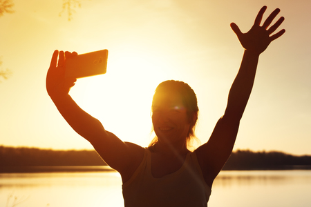Young happy girl making selfie picture outdoorsの写真素材
