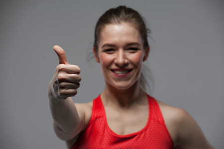 Happy sports woman showing thumbs up gestureの写真素材
