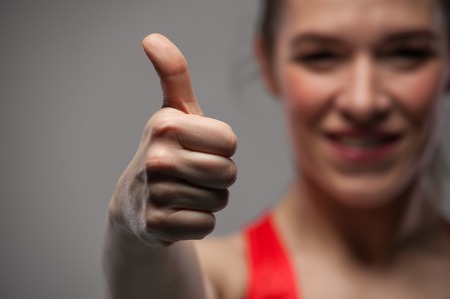 Happy sports woman showing thumbs up gestureの写真素材