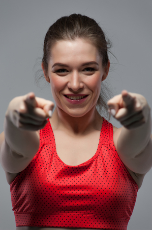 Fitness girl pointing her fingers to youの写真素材