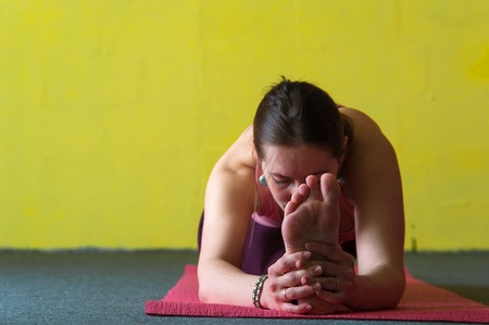 Young woman practicing yoga in class