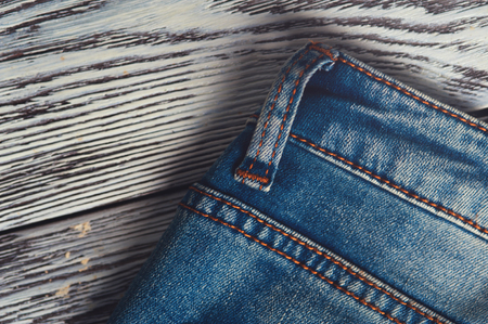 Closeup of blue denim jeans on wooden tableの写真素材