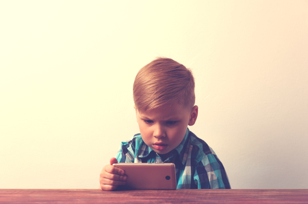 Serious caucasin child using smartphoneの写真素材