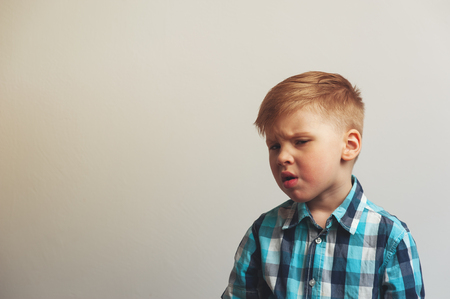 Portrait of unhappy and tired caucasian child on white background. Frustration and depression.の写真素材