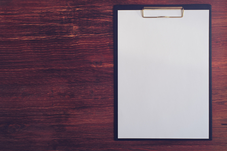 Empty clipboard on wooden table, top viewの写真素材