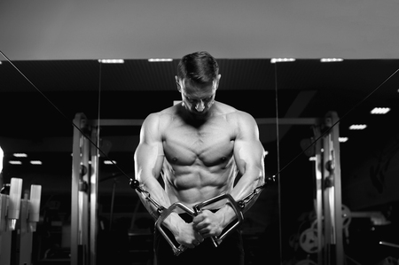 Male fitness model with naked torso posing in gymの写真素材