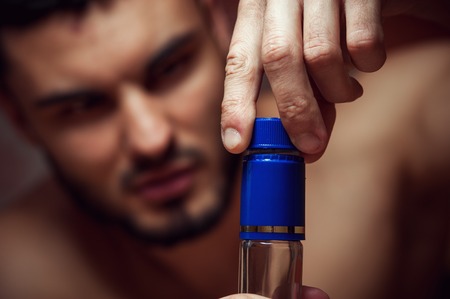 Drunk male adult opening alcohol bottleの写真素材