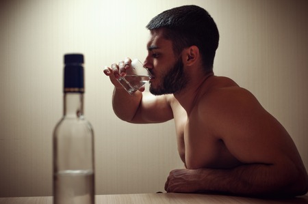 Portrait of young depressed man drinking alcoholの写真素材