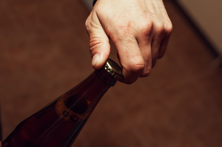 Closeup of male hands opening beer bottle.の写真素材
