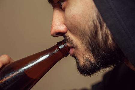 Closeup of Young drunk man with beer bottleの写真素材