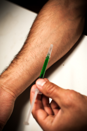 Male adult preparing syringe to narcotic injectionの写真素材