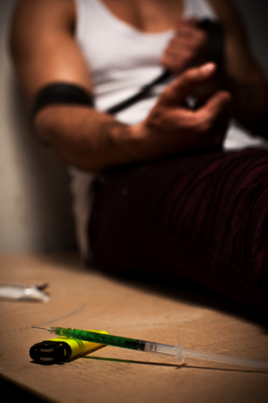 Drug addicted person sitting near wall aloneの写真素材