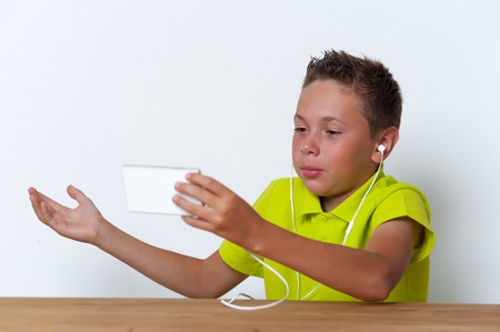 Tween boy with smartphone and earphonesの写真素材