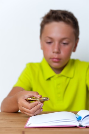 Tween school boy playing fidget spinnerの写真素材