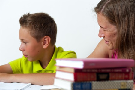 Tween boy doing homework with his mother.の写真素材