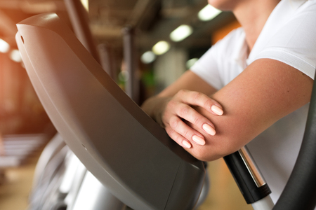 Closeup of female exercising on elliptical machineの写真素材