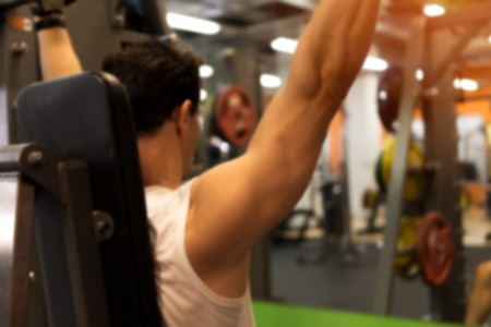 Blurred picture of exercising male in gymの写真素材