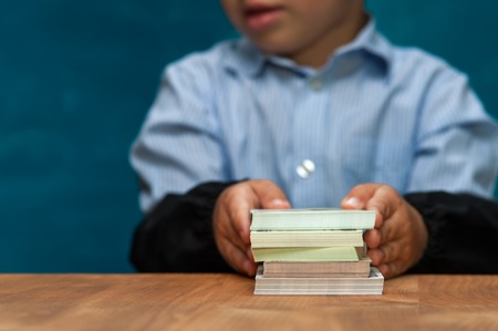 Little stylish boy counting money at workplaceの写真素材