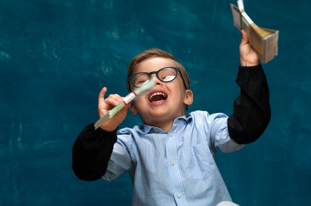 Happy smiling child wearing eyeglasses with cashの写真素材