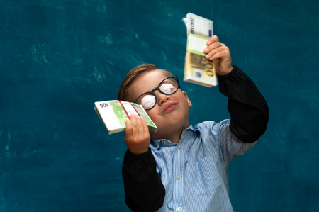 Happy smiling child wearing eyeglasses with cashの写真素材