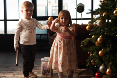 Cute children decorating Christmas tree with toysの写真素材
