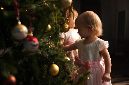 Little toddler girl standing near Christmas treeの写真素材
