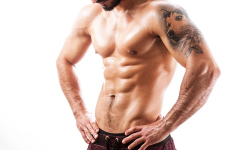 Athletic young man looking at his abdominal