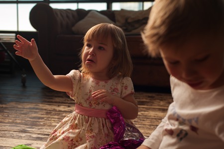 Upset children sitting next to Christmas treeの写真素材