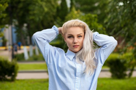 Attractive blonde female with long hair in parkの写真素材