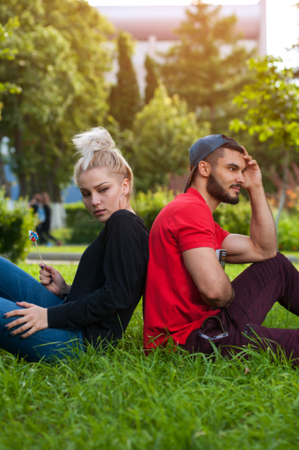 Romantic couple sitting on green grass in park.の写真素材