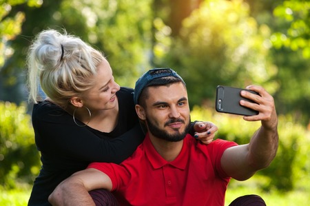 Young romantic couple making selfie outdoorsの写真素材
