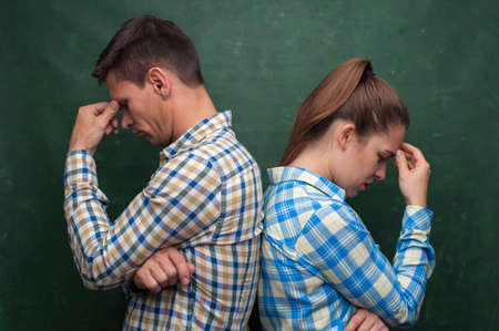 Marital quarrel concept.  Middle-aged couple pretty woman and pensive man stands back to back and...