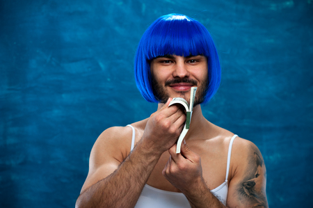 Cross dressing person posing with stack of moneyの写真素材