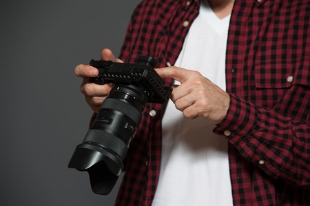 Closeup - male photographer setting the cameraの写真素材